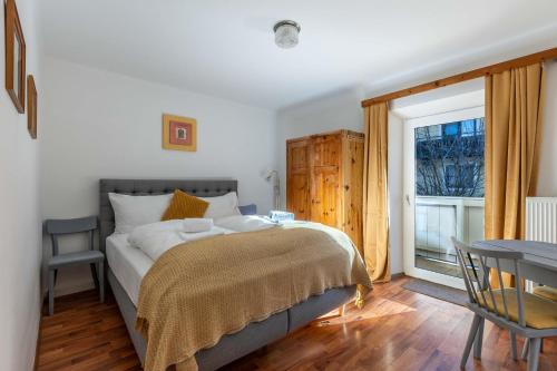 a bedroom with a bed and a table and a window at Lovely Rita, Appartement Kaprun in Kaprun