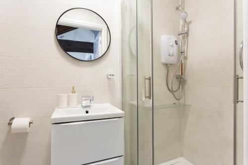 a bathroom with a shower and a sink and a mirror at Bradford Luxury Central Apartment in Bradford