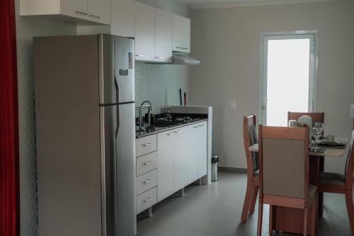 a kitchen with a stainless steel refrigerator and a table at Quality - Boas Vistas in Canoa Quebrada