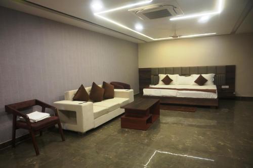 a bedroom with a bed and a couch and a table at MOUNT VIEW HOTEL in Ajmer