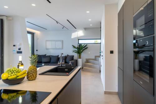 a kitchen and living room with a counter and fruits on a counter top at Aethra Villas Luxury Retreat in Anissaras