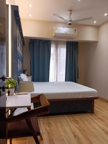 a bedroom with a bed and a ceiling fan at Satya Stays Premium Boutique Apartment in Navi Mumbai