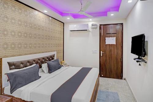 a bedroom with a large bed with a purple ceiling at New Green Plaza in New Delhi