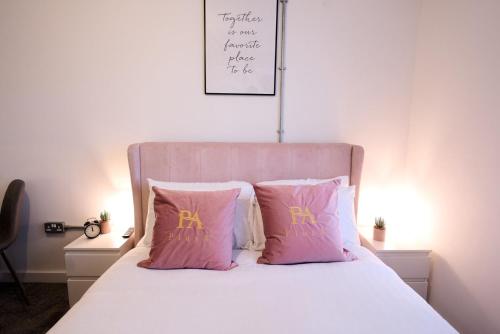 a bed with pink and gold pillows on it at Modern Living 1Bed in Central Warrington in Warrington