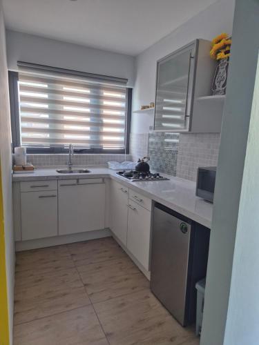 a kitchen with white cabinets and a sink at Sunflower-Lodge in Willemstad