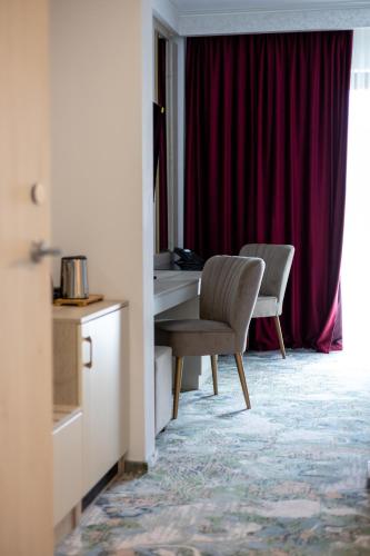 a hotel room with a desk and a chair at CHITULESCU Hotel in Târgovişte