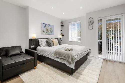 a bedroom with a bed and a couch at Jasmine Suite by Yielding Bricks in London