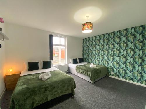a bedroom with two beds and a window at 5 bedroom Luxury Townhouse near City Centre, sleep 16 in Manchester