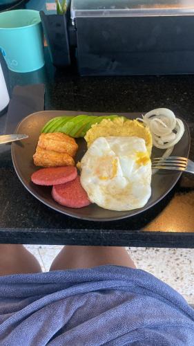 Un plato de comida con huevos y fruta en una mesa. en Estancia Nana Tu Refugio con Vista al Mar, Piscina, wifi, lavadora secadora Reserva Ahora, en Juan Dolio