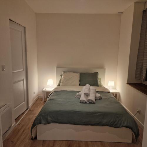 une chambre avec un lit avec deux serviettes dessus dans l'établissement Bel appartement cosy, à Fleury-les-Aubrais