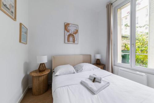 une chambre avec un lit blanc avec deux serviettes dessus dans l'établissement Appartement 40m2 Parc des Expositions - 6P - FLAT-GUEST, à Malakoff