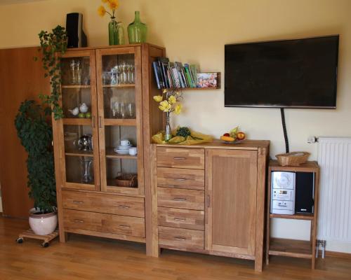 a wooden entertainment center with a television on a wall at Ferienwohnung Freißl in Rottenbuch