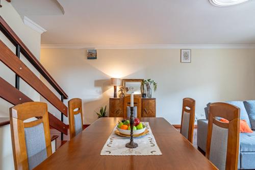 una mesa de comedor con un bol de fruta. en Casa da Abegoaria, en Caniço
