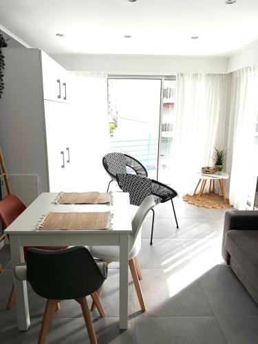 un salon avec une table et des chaises blanches dans l'établissement Studio Le Saint Honorât Juan les pins, à Antibes