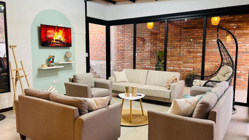 a living room with couches and a brick wall at Casa-Refugio Del Sol in Vilcabamba