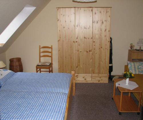 a bedroom with a bed and a large wooden cabinet at Ferienwohnungen Langholz in Hohn