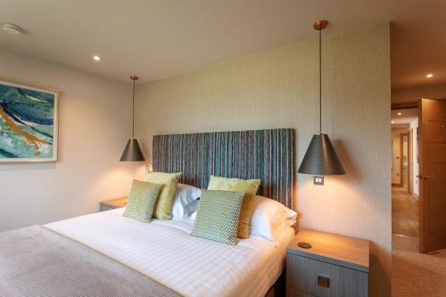 a bedroom with a white bed with two pillows at Les Ormes Resort in St Brelade