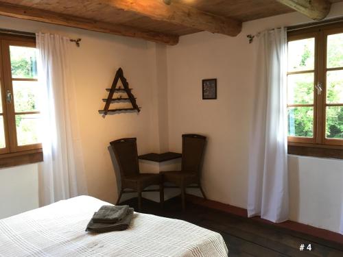 a bedroom with a bed and a table and chairs at Les Trois Noyers in Tailhac