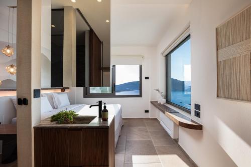 a bedroom with a bed and a large window at Rokkea Villa in Plakias