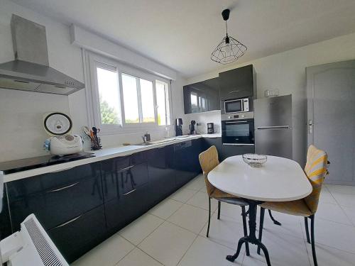 une cuisine avec une table blanche et un comptoir blanc dans l'établissement Sérénité, à Lit-et-Mixe