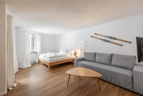 a living room with a couch and a bed at 2302 Charmante 2,5-Zimmer-Wohnung mit Suedbalkon und stilvoller Einrichtung in Vulpera