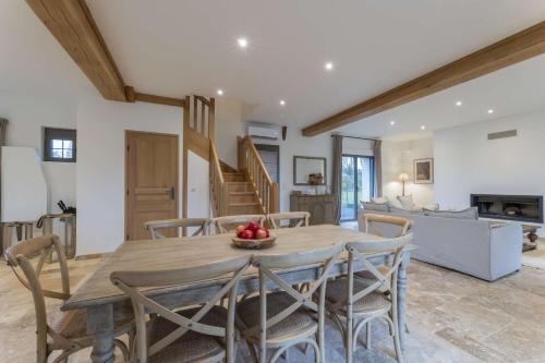 une salle à manger et un salon avec une table et des chaises dans l'établissement Maison des Pommiers Elegant house near Deauville, à Cricquebœuf