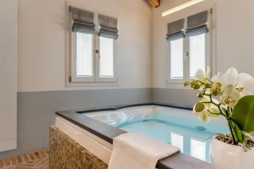 a jacuzzi tub in a room with windows at Relais Barchessa Molon in Campo di Pietra