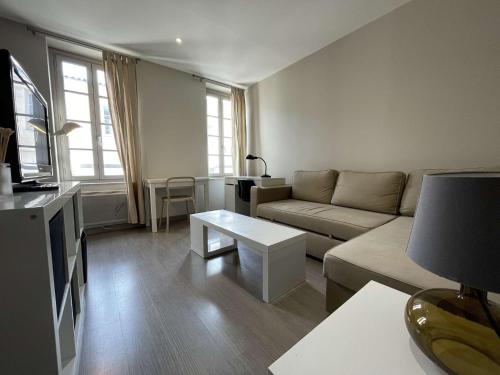 un salon avec un canapé et une table dans l'établissement Appartement T2 à La Rochelle - LR180-004, à La Rochelle