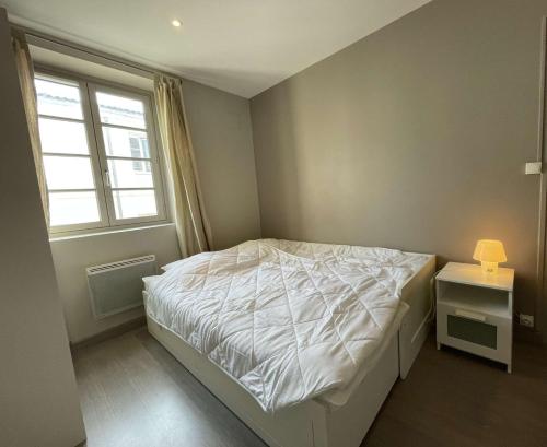 une chambre avec un lit blanc et une fenêtre dans l'établissement Appartement T2 à La Rochelle - LR180-004, à La Rochelle