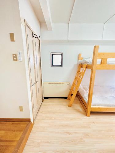 a room with two bunk beds and a ladder at L!fe Apartment Hakuba in Hakuba