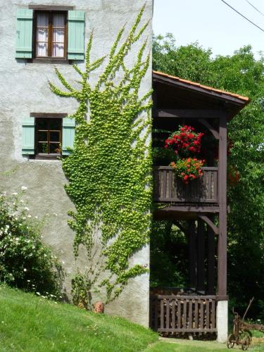 a building with a balcony with flowers on it at Les Trois Noyers in Tailhac