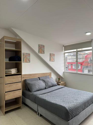 a bedroom with a bed and a book shelf at Hostelfc San Luis in Bogotá