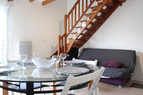 une salle à manger avec une table en verre et un canapé dans l'établissement Appt Studio mezza LA ROCHELLE - LR100-473, à La Rochelle