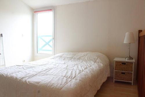 une chambre avec un lit blanc et une fenêtre dans l'établissement Appt Studio mezza LA ROCHELLE - LR100-473, à La Rochelle