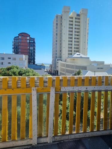 a yellow fence with buildings in the background at Yello Hotel in Strand