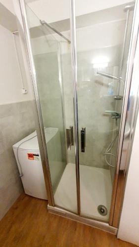 une douche avec une porte vitrée dans une salle de bain dans l'établissement Le studio mer dune et farniente, à La Grande Motte