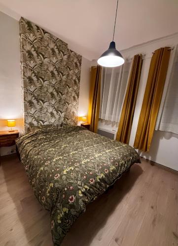 une chambre avec un lit avec un couvre-lit fleuri dans l'établissement Le Cottage Malouin, à Dunkerque