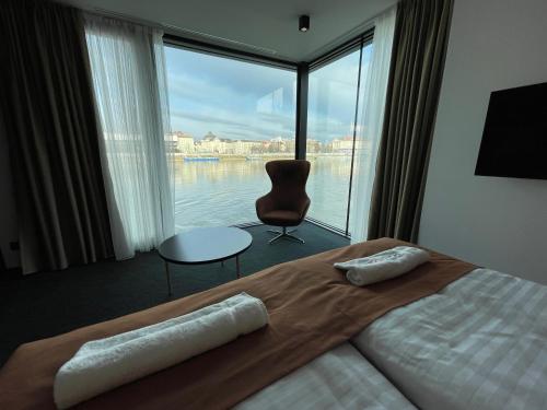 a bedroom with a bed with a view of the water at Ponton Rooms in Bratislava