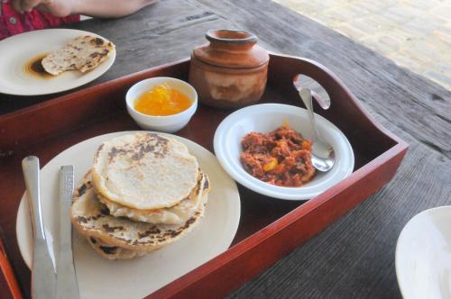 a tray of food with a plate of food and some food at Atulya Lake View Mirissa - Resort and Spa in Mirissa
