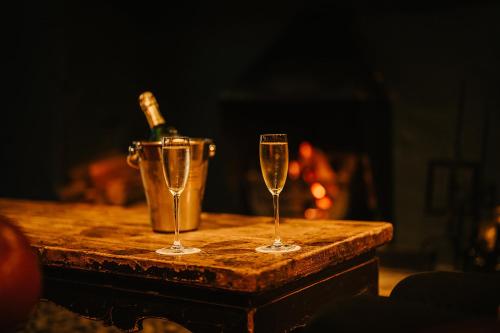 two glasses of champagne on a table next to a bucket at The Lygon Arms - an Iconic Luxury Hotel in Broadway