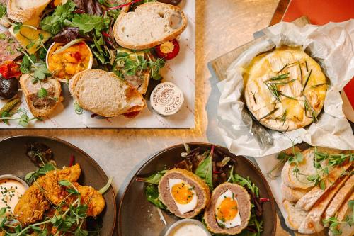 a table topped with plates of sandwiches and salad at The Lygon Arms - an Iconic Luxury Hotel in Broadway