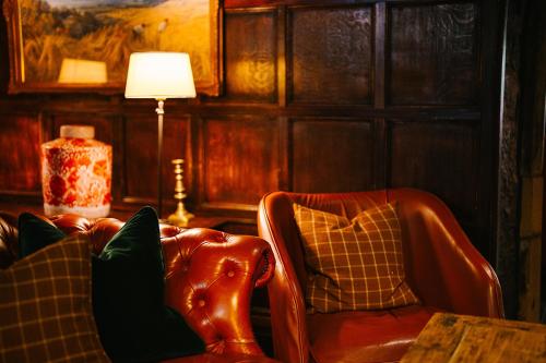 a living room with a chair and a lamp at The Lygon Arms - an Iconic Luxury Hotel in Broadway
