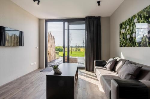 a living room with a couch and a table at Appartementen De Wilg - Adults only in Noordwijk aan Zee