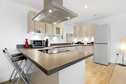 a kitchen with white cabinets and a black counter top at Portfolio Apartments - Stevenage Town Centre in Stevenage