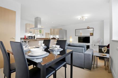 a dining room and living room with a table and chairs at Portfolio Apartments - Stevenage Town Centre in Stevenage