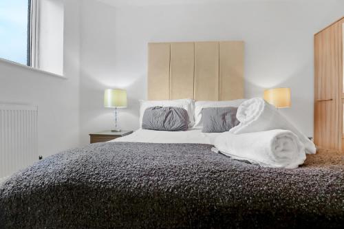a bedroom with a bed with white sheets and pillows at Portfolio Apartments - Stevenage Town Centre in Stevenage