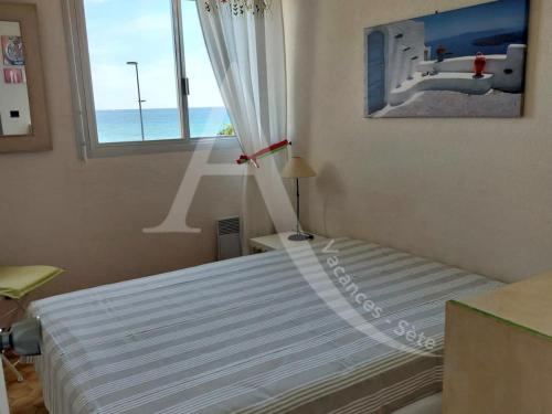 une chambre avec un lit avec vue sur l'océan dans l'établissement coquet appartement 1 chambre avec parking bord de plage, à Sète