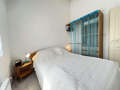 une chambre avec un lit blanc et une fenêtre dans l'établissement Maison 3 pièces mezzanine CHATELAILLON PLAGE - CL080-046, à Châtelaillon-Plage