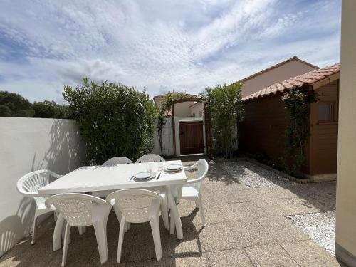 une table blanche et des chaises sur une terrasse dans l'établissement Maison 3 pièces mezzanine CHATELAILLON PLAGE - CL080-046, à Châtelaillon-Plage
