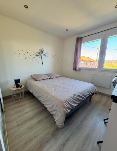 - une chambre avec un lit et un arbre sur le mur dans l'établissement Chez Nico - 100 m plages - clim - jardin - parking - Quartier calme, à Saint-Chamas